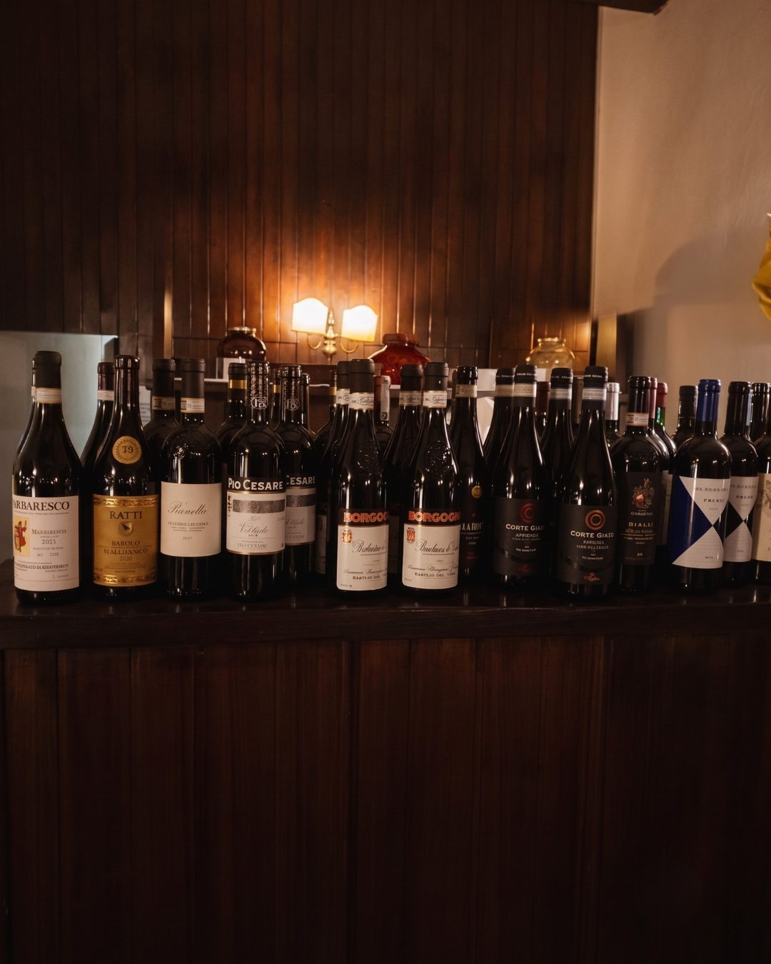 Scaffale con una selezione di vini rossi e Lambrusco